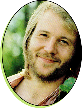 A man with long hair and beard smiling.