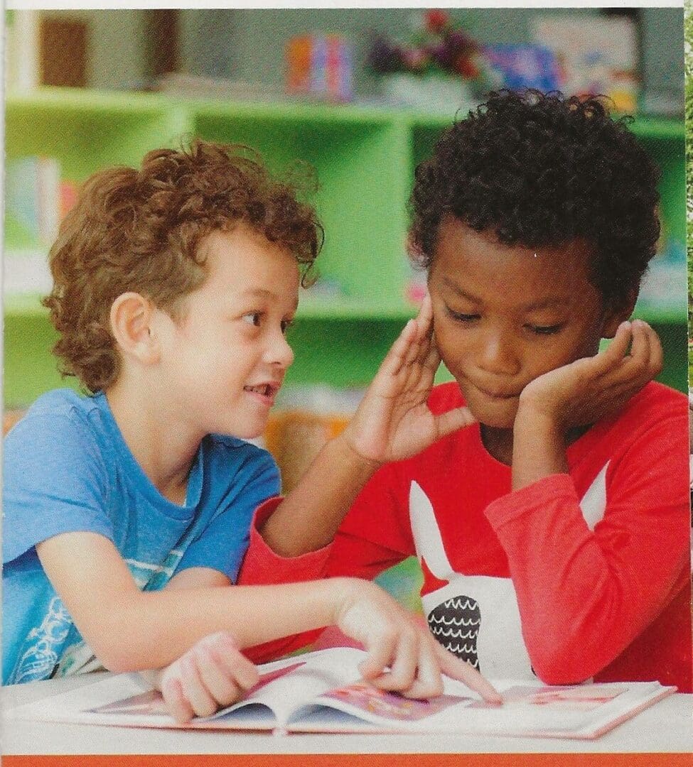 Two children are reading a book together.