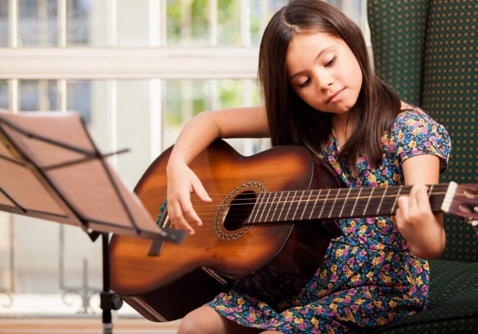 A girl is playing an acoustic guitar